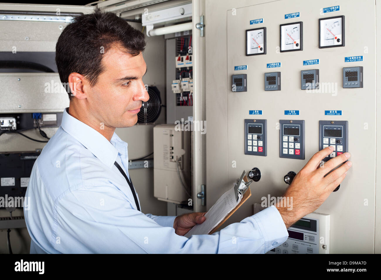 professional industrial engineer adjusting modern machine settings Stock Photo