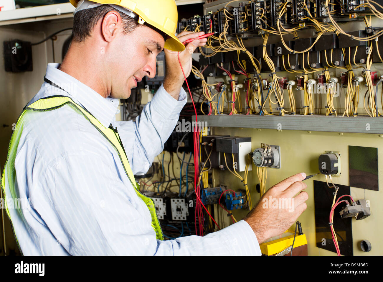 male Caucasian electrician testing industrial machine Stock Photo