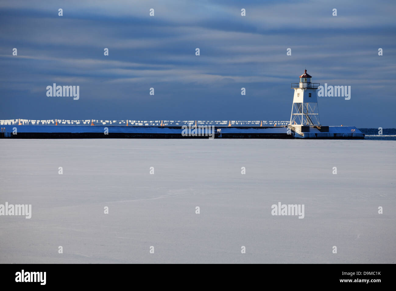 Early morning view of breakwater lighthouse and glistening ice covered cables in winter.  Grand Marais, Minnesota. Stock Photo