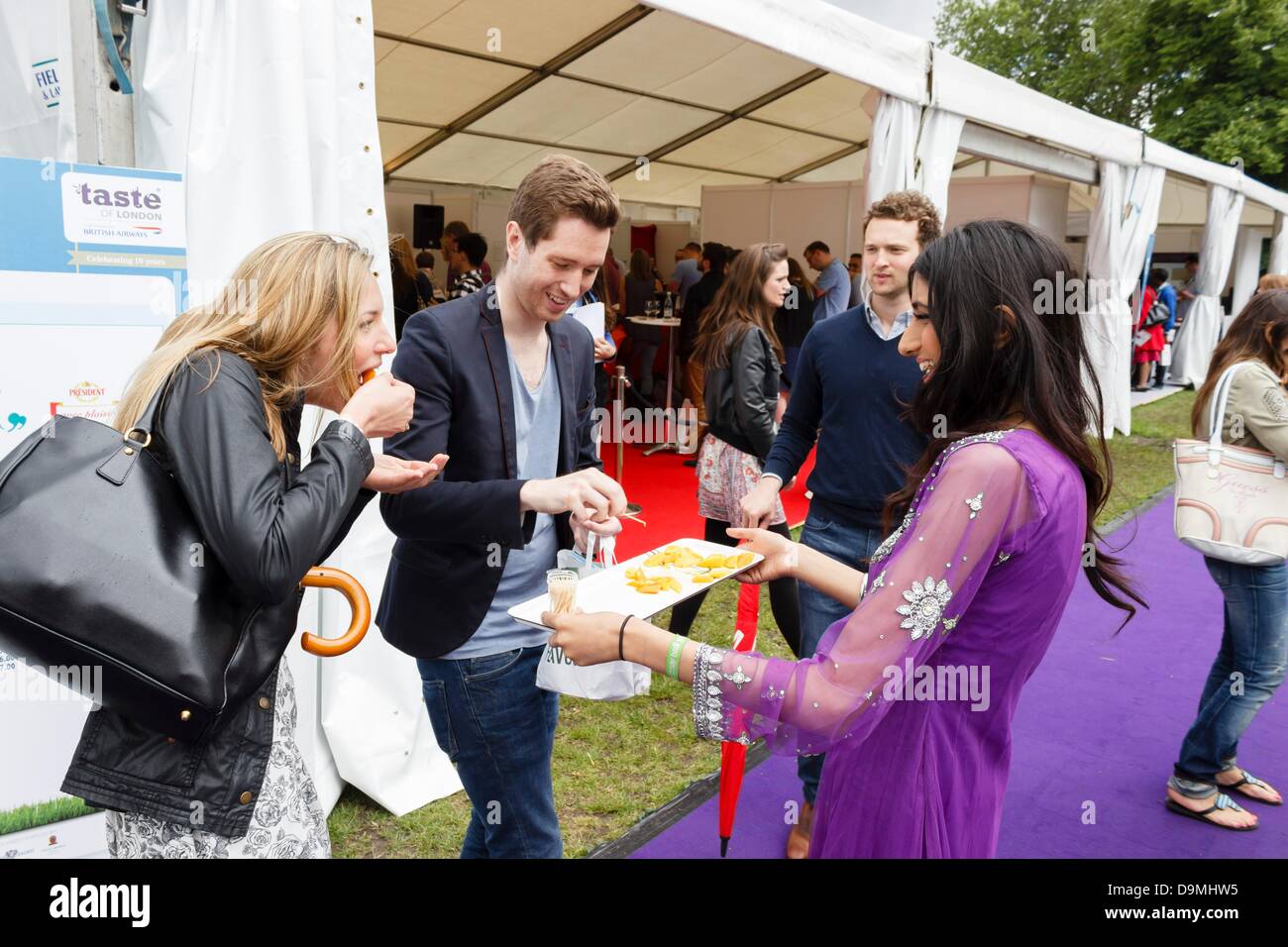 London, UK. 22nd June 2013. Taste of London 2013, visitors sample mango fruit. The event takes place every year in Regents Park, where 40 of the city's top restaurants serve their finest dishes for visitors to sample. London, UK. 22nd June 2013. Photo: Paul Maguire/Alamy Live News Stock Photo