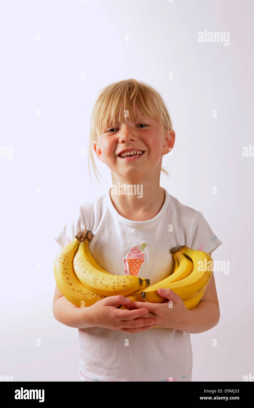 Healthy young girl with bananas in her arms. Promoting Heathy eating