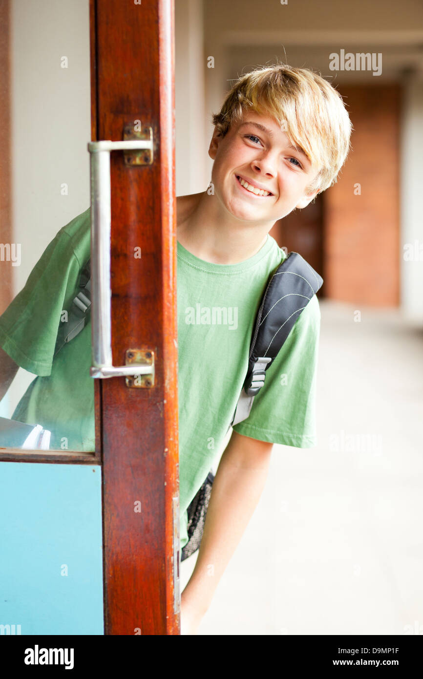 cute high school boy behind classroom door Stock Photo