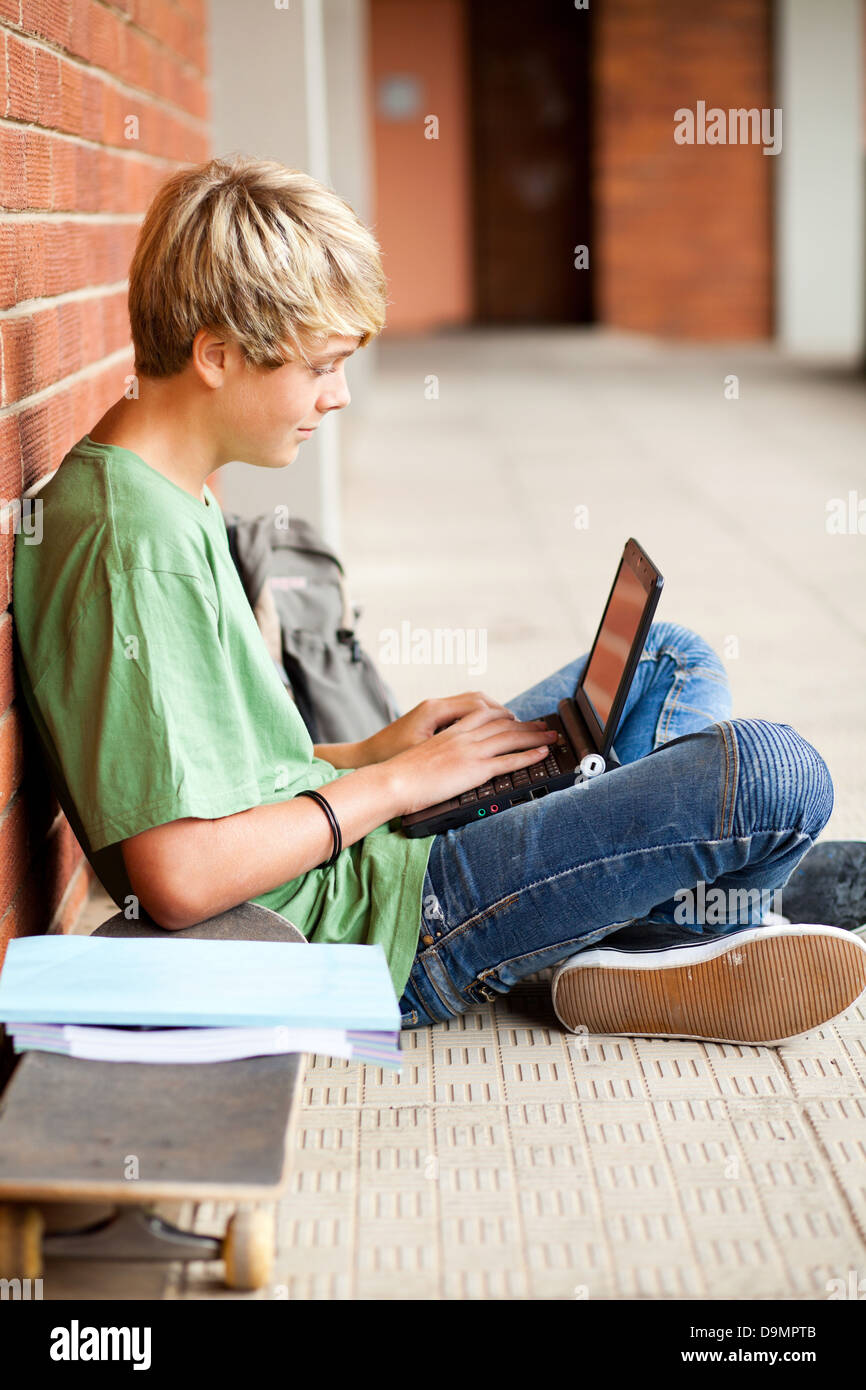male high school student using laptop in school Stock Photo