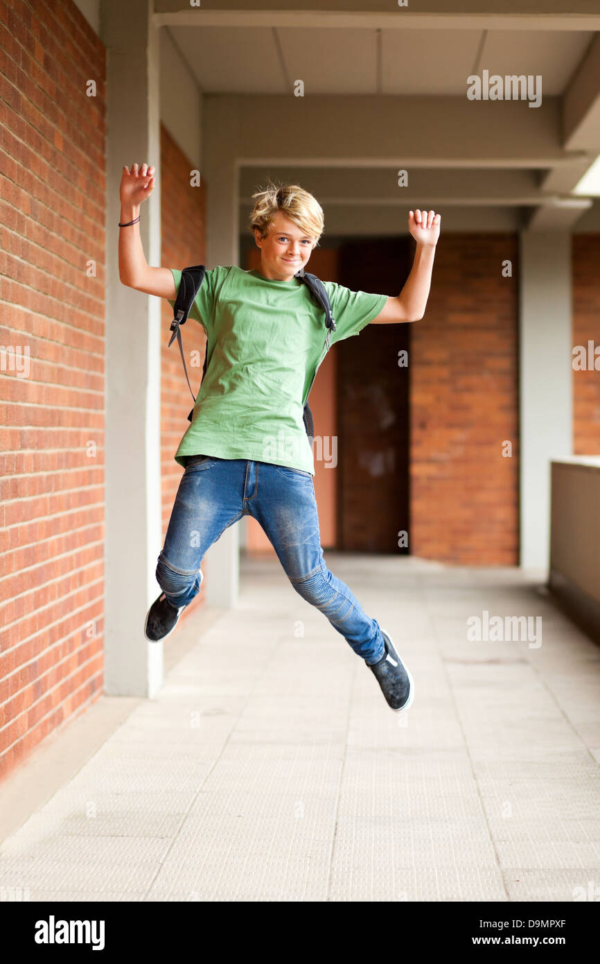 happy male high school student jumping up in school Stock Photo