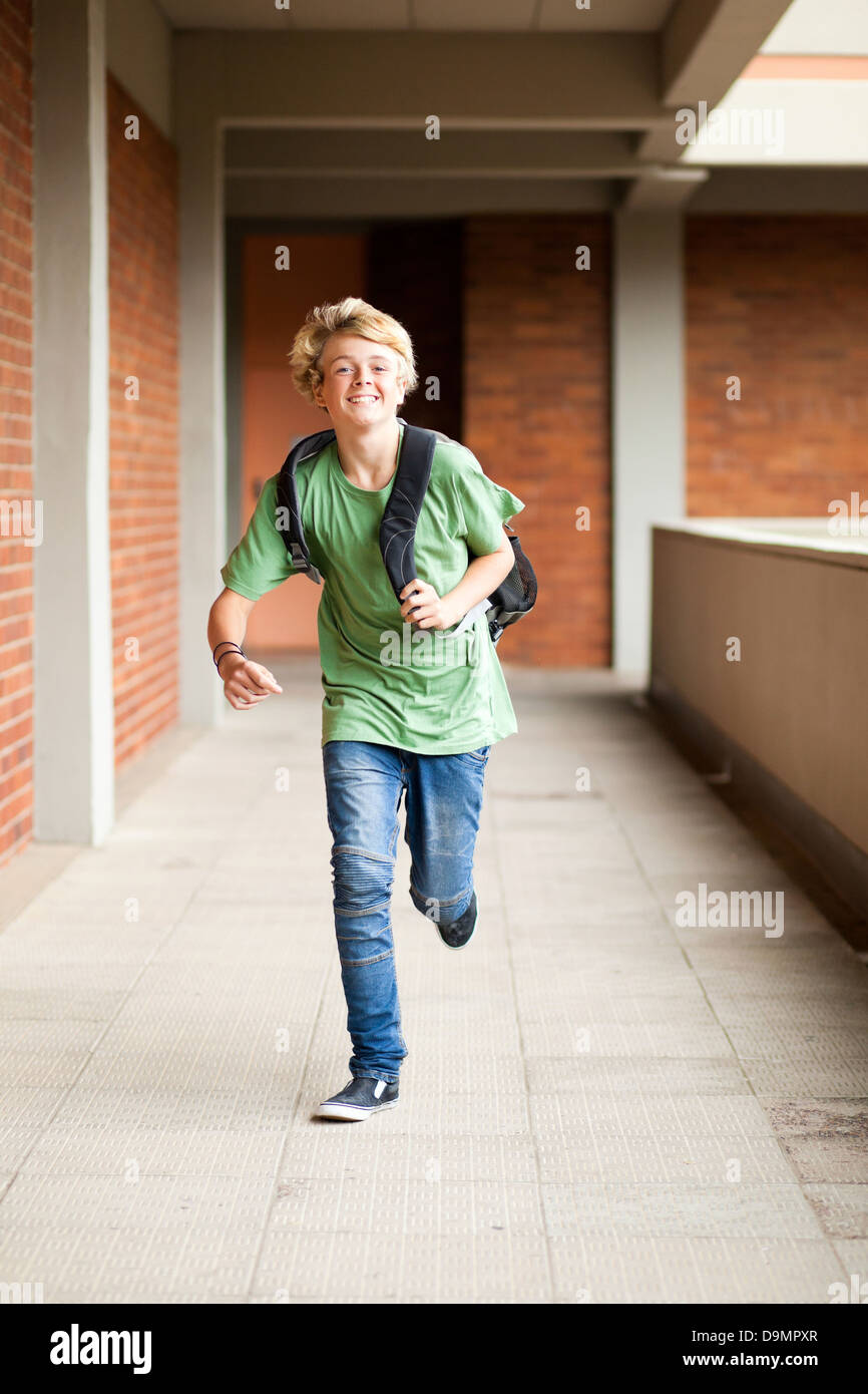 male middle school student running in school passage Stock Photo