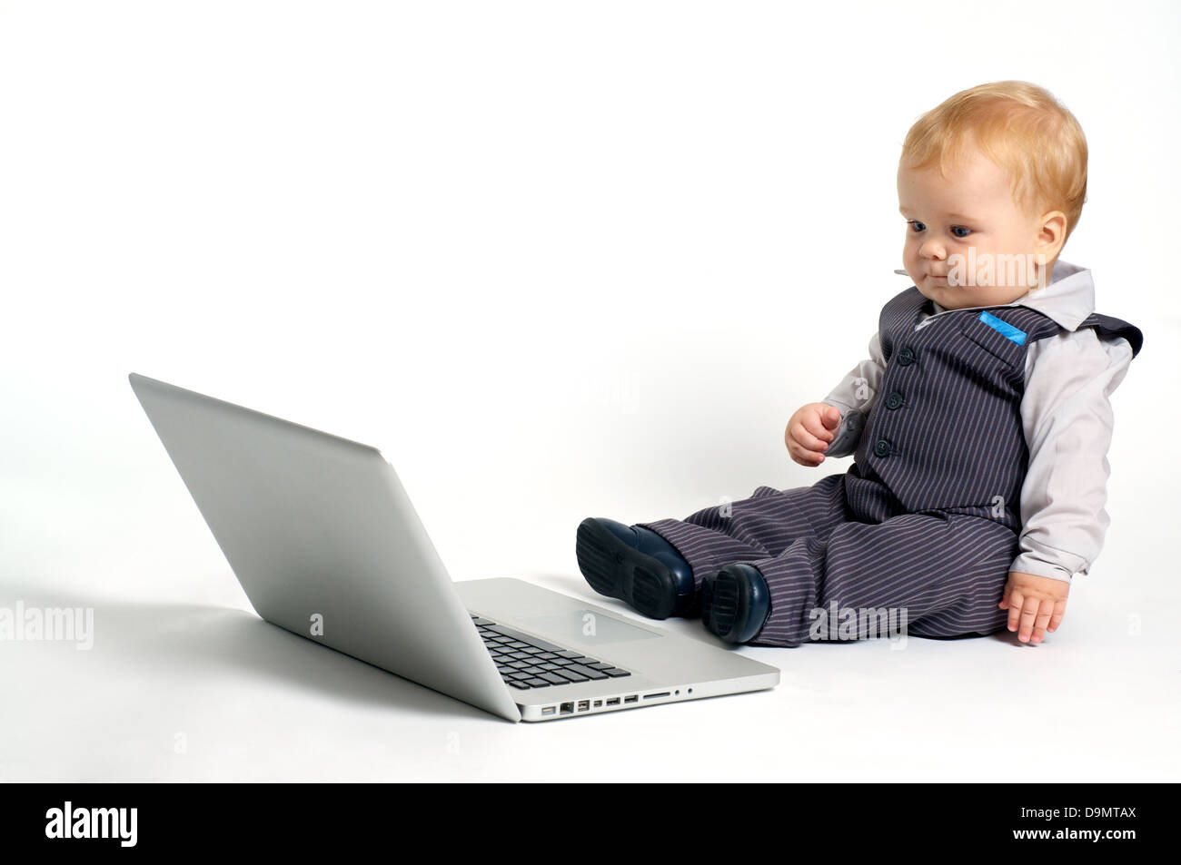 blond baby in suit working with laptop Stock Photo