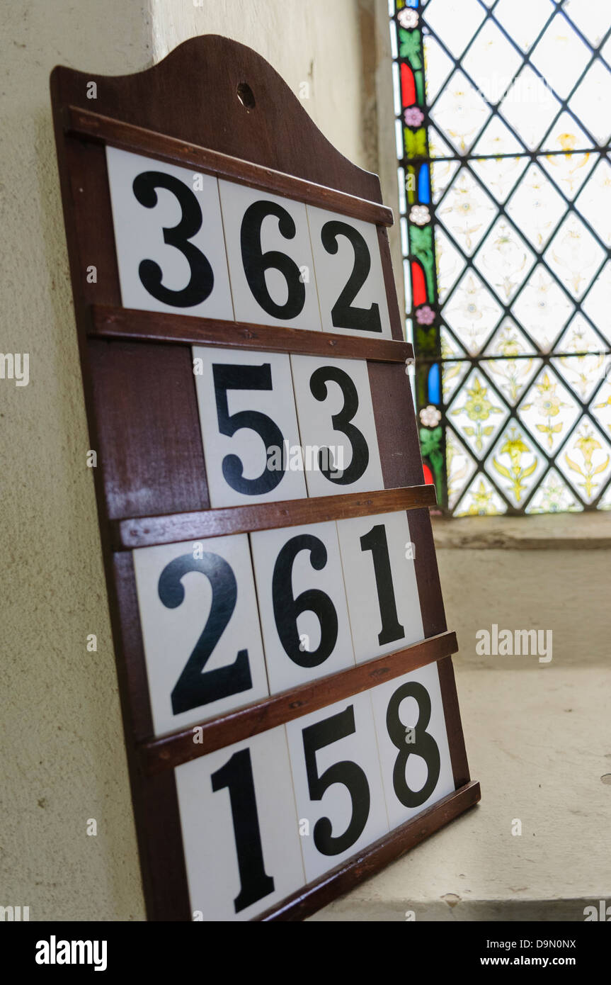 Hymn board set against a window in a Church of England. Stock Photo