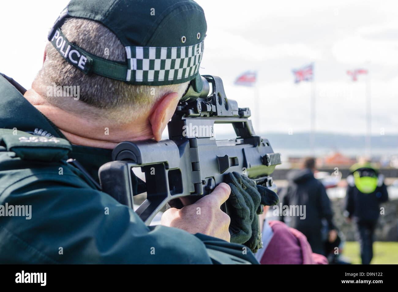 Police officer looks through the sights of a Heckler and Koch G36C automatic machine gun Stock Photo