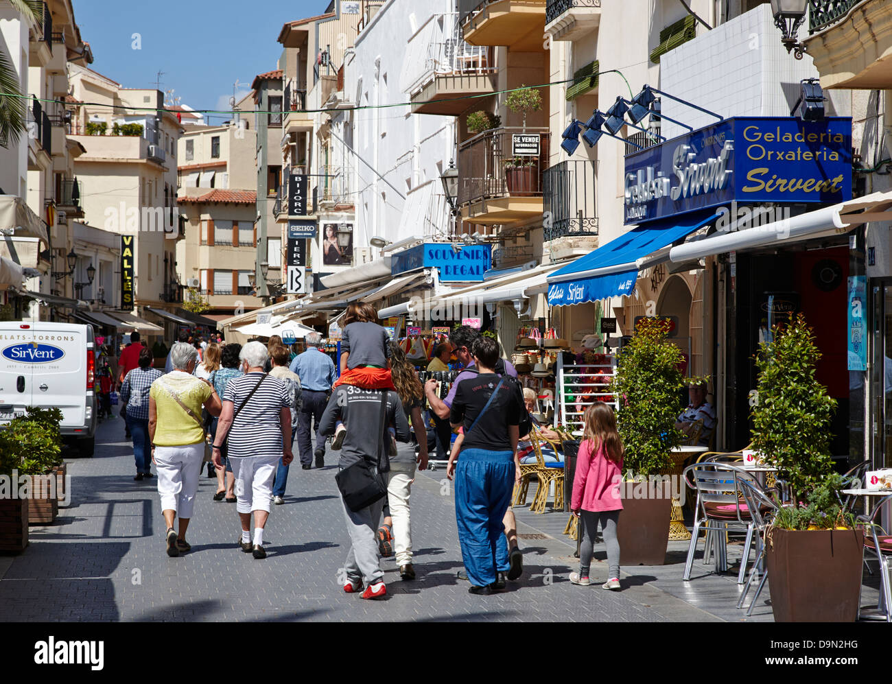 people walking through narrow busy shopping streets of la platja Cambrils Catalonia Spain Stock Photo