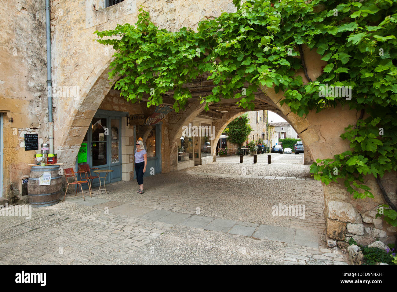 One of the many arches with shops and cafes around the Place des Cornieres in Monpazier, Dordogne, France Stock Photo