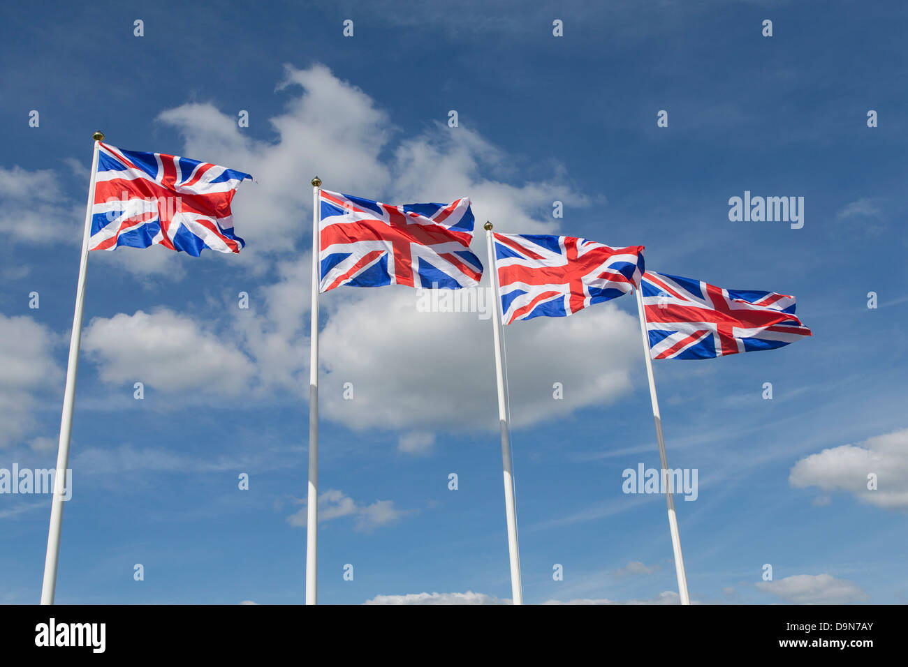 Four Union Jack Flags on Flagpoles. British Flags Stock Photo