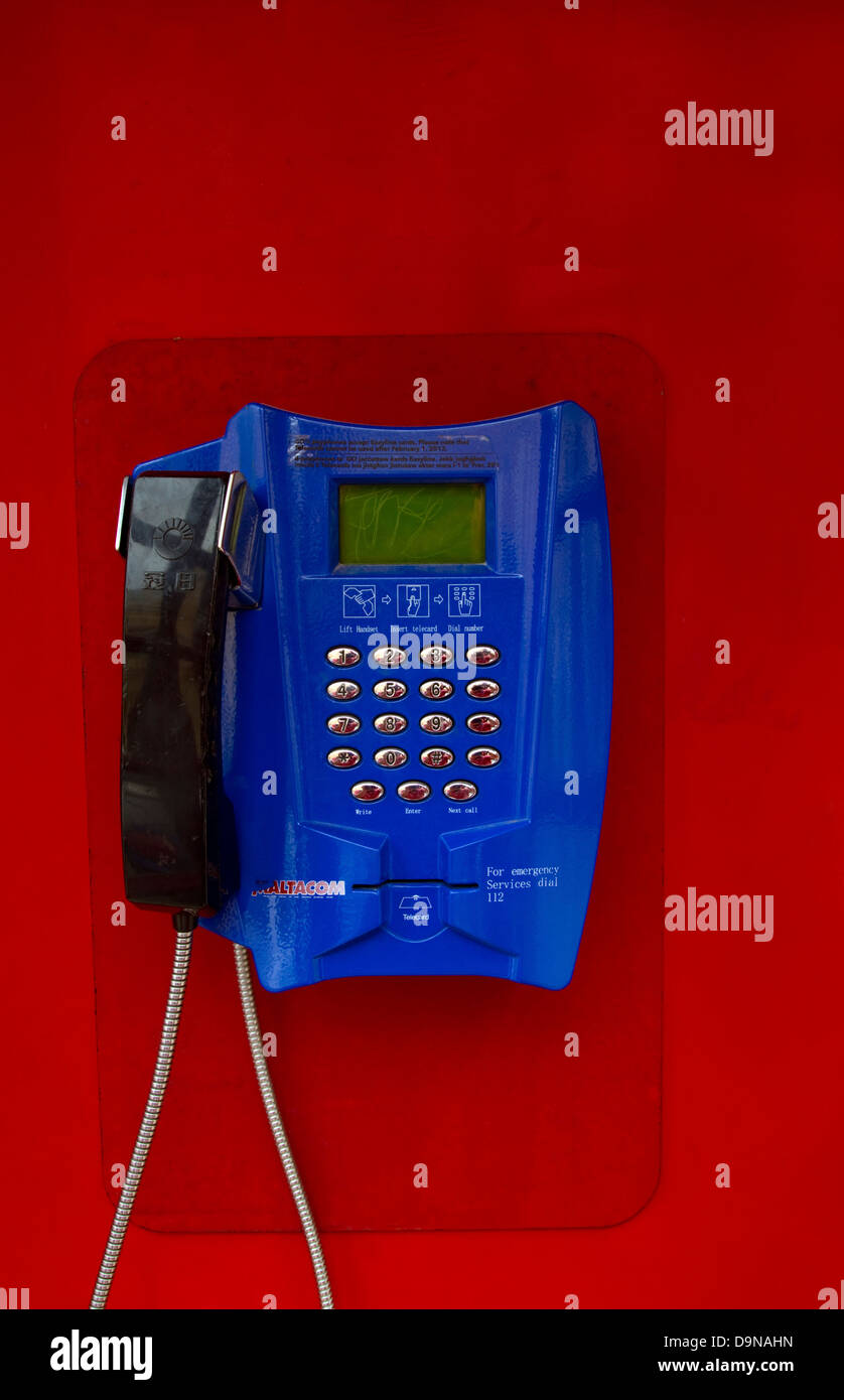Blue coloured public telephone showing receiver and crome coloured push button controls Stock Photo