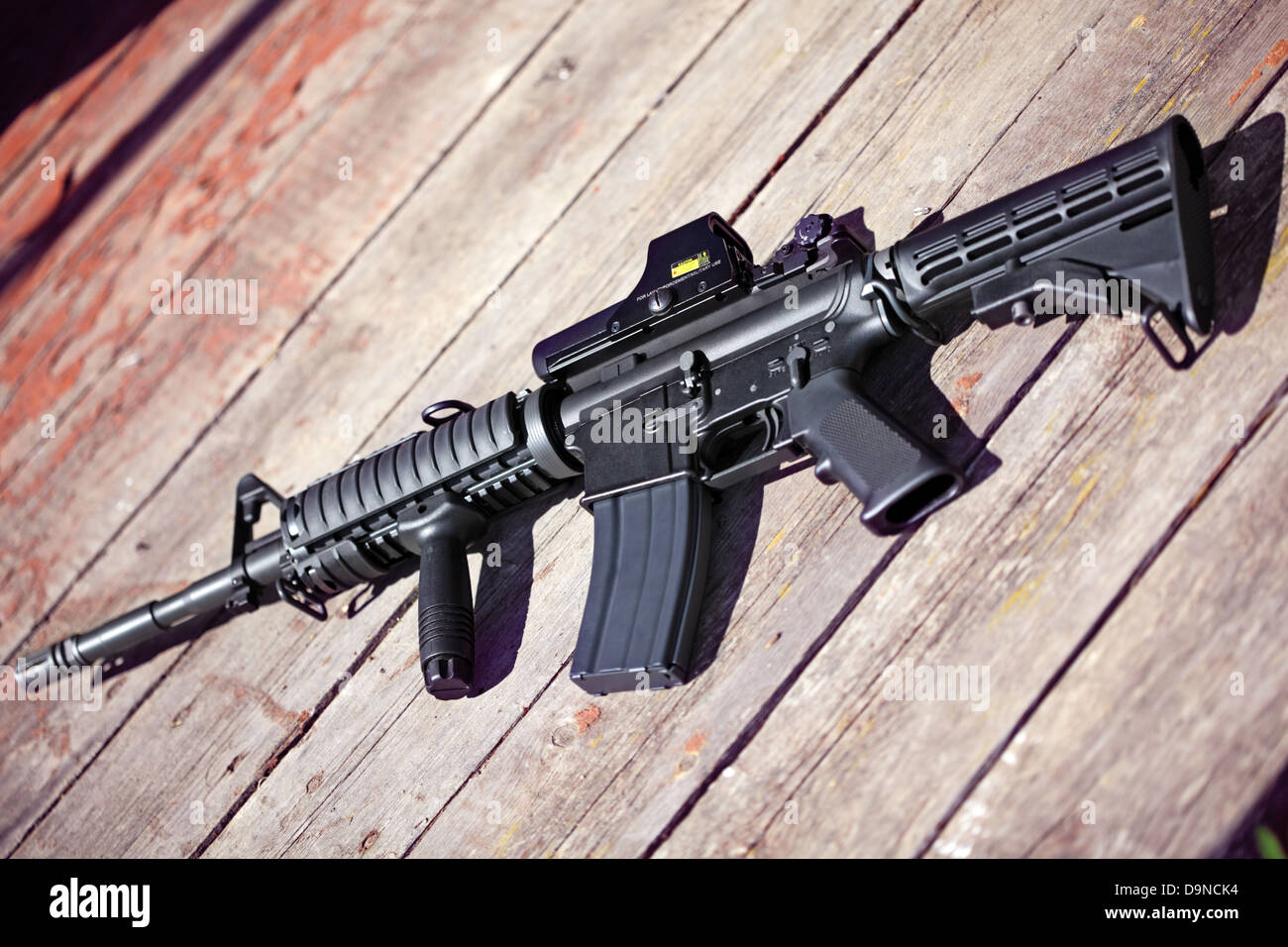 The Black Rifle. AR-15 assault carbine (M4A1) on a wooden surface. Shallow DOF. Stock Photo