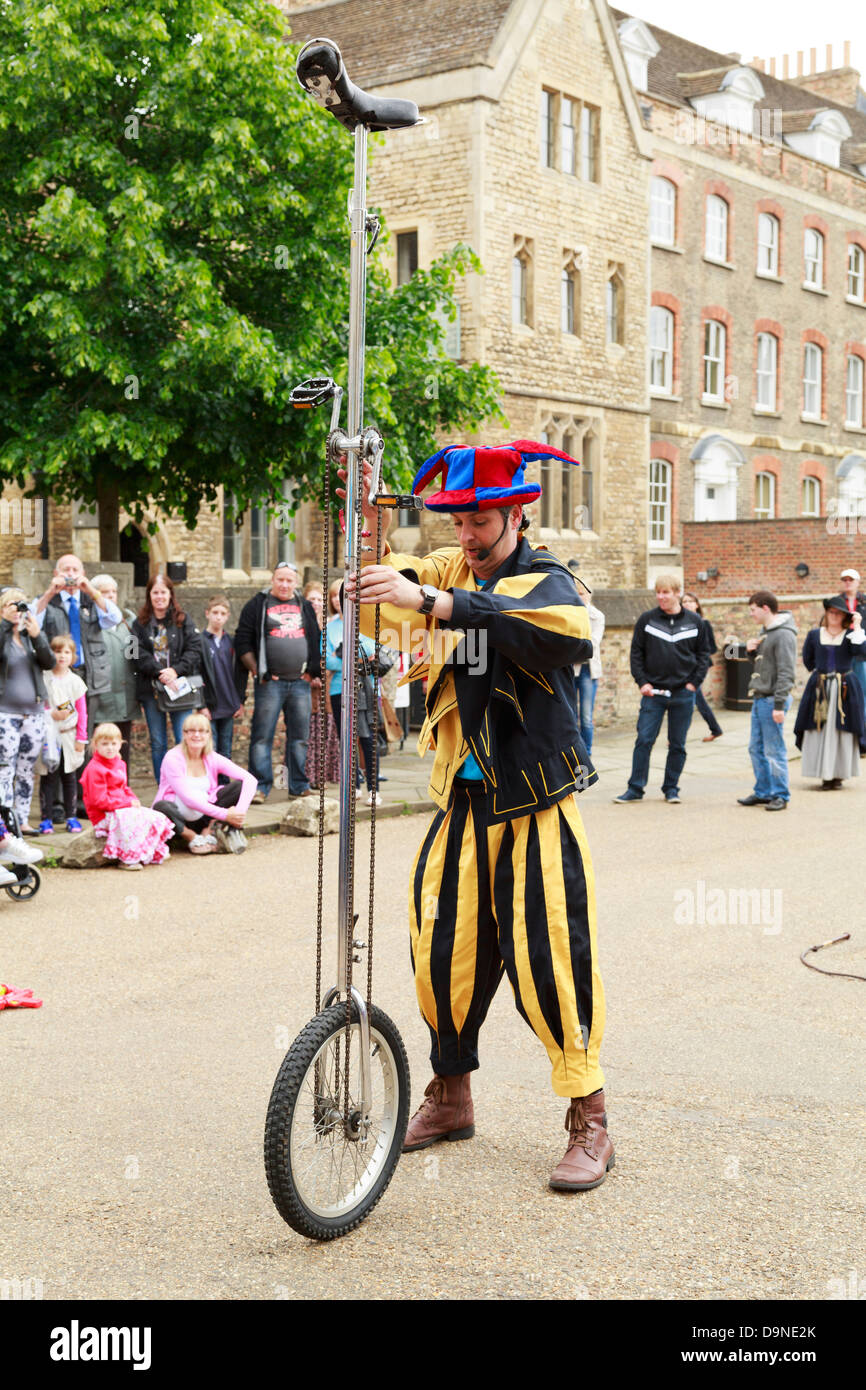 Jester attempting to ride a tall unicycle, Peterborough Heritage Festival 22 June 2013, England Stock Photo