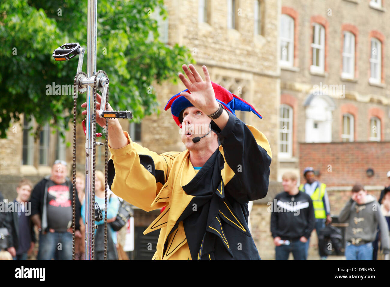Jester attempting to ride a tall unicycle, Peterborough Heritage Festival 22 June 2013, England Stock Photo