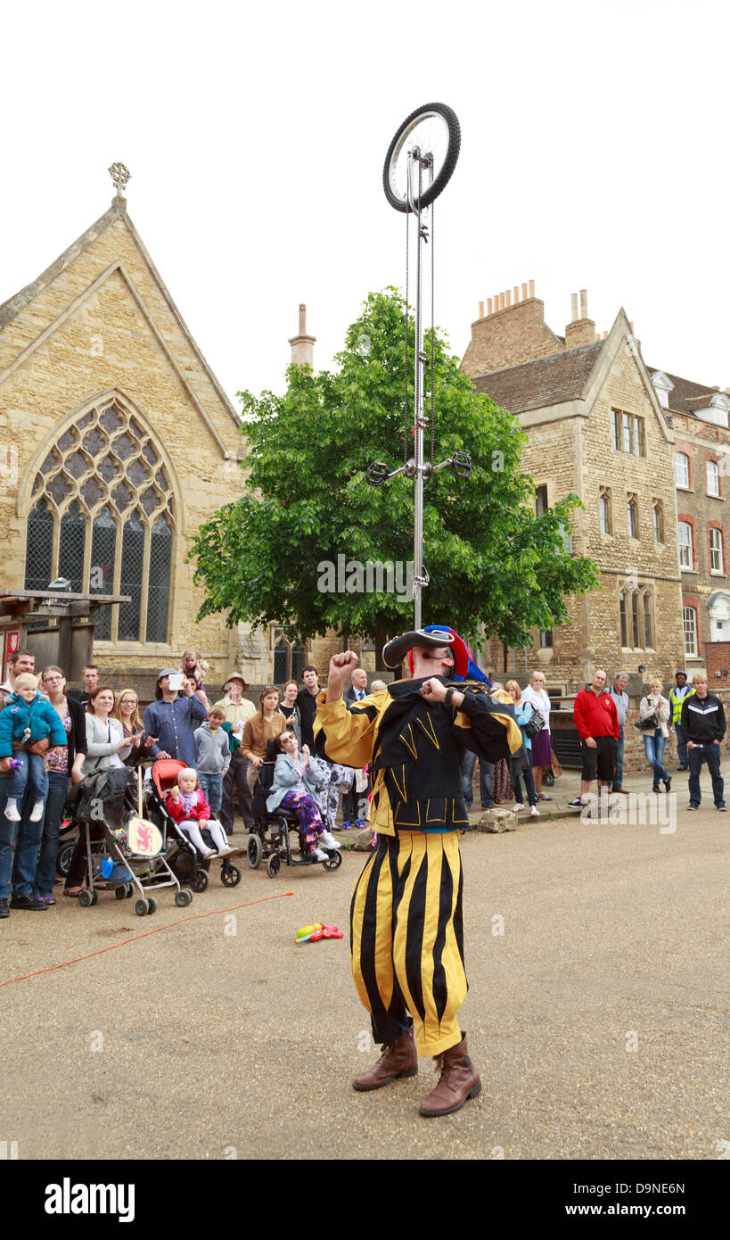 Jester balancing a unicycle with his mouth, Peterborough Heritage Festival 22 June 2013, England Stock Photo