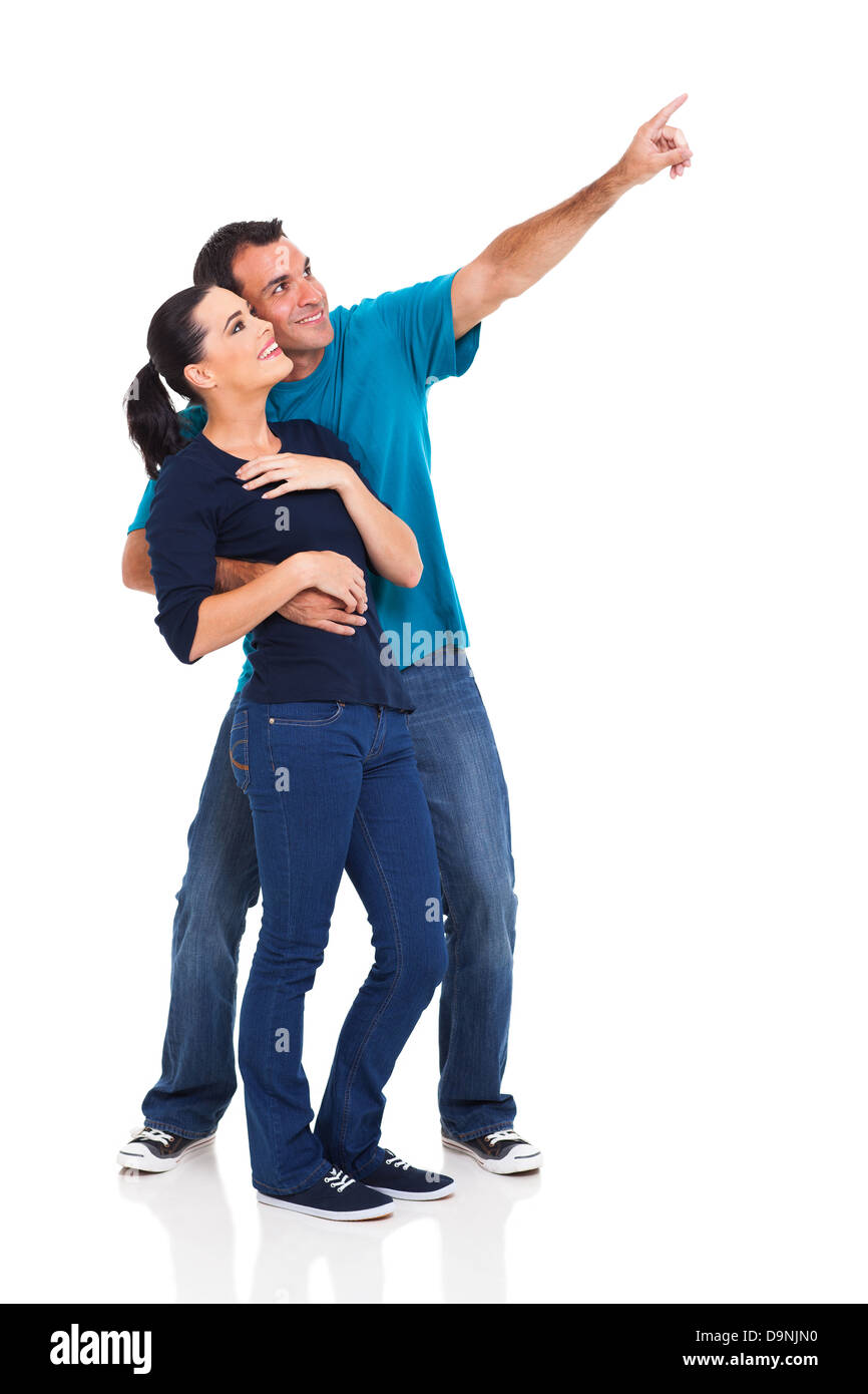 happy playful couple pointing away on white background Stock Photo - Alamy