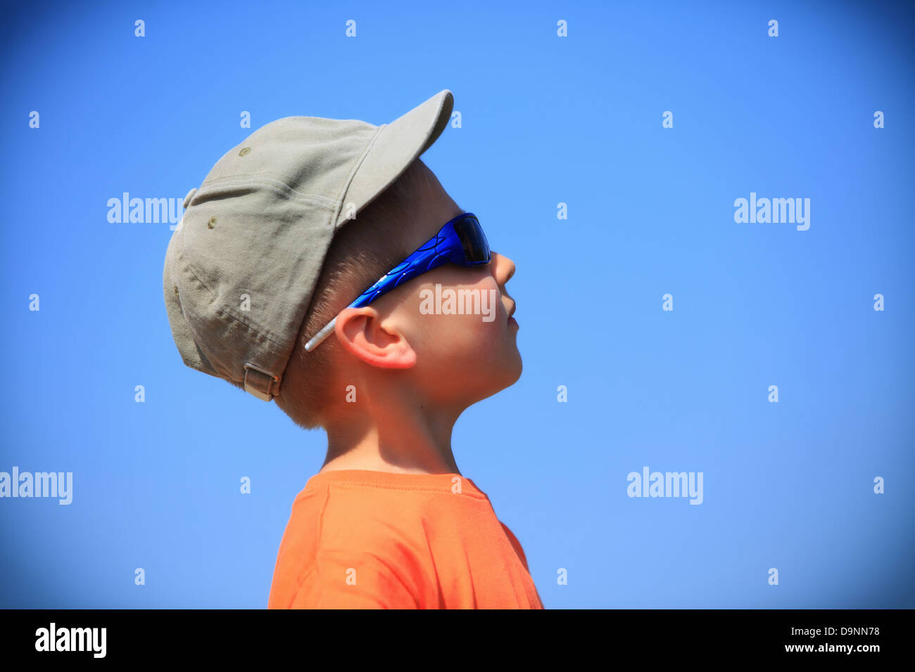 Little boy kid with sunglasses and cap outdoor sky background Stock