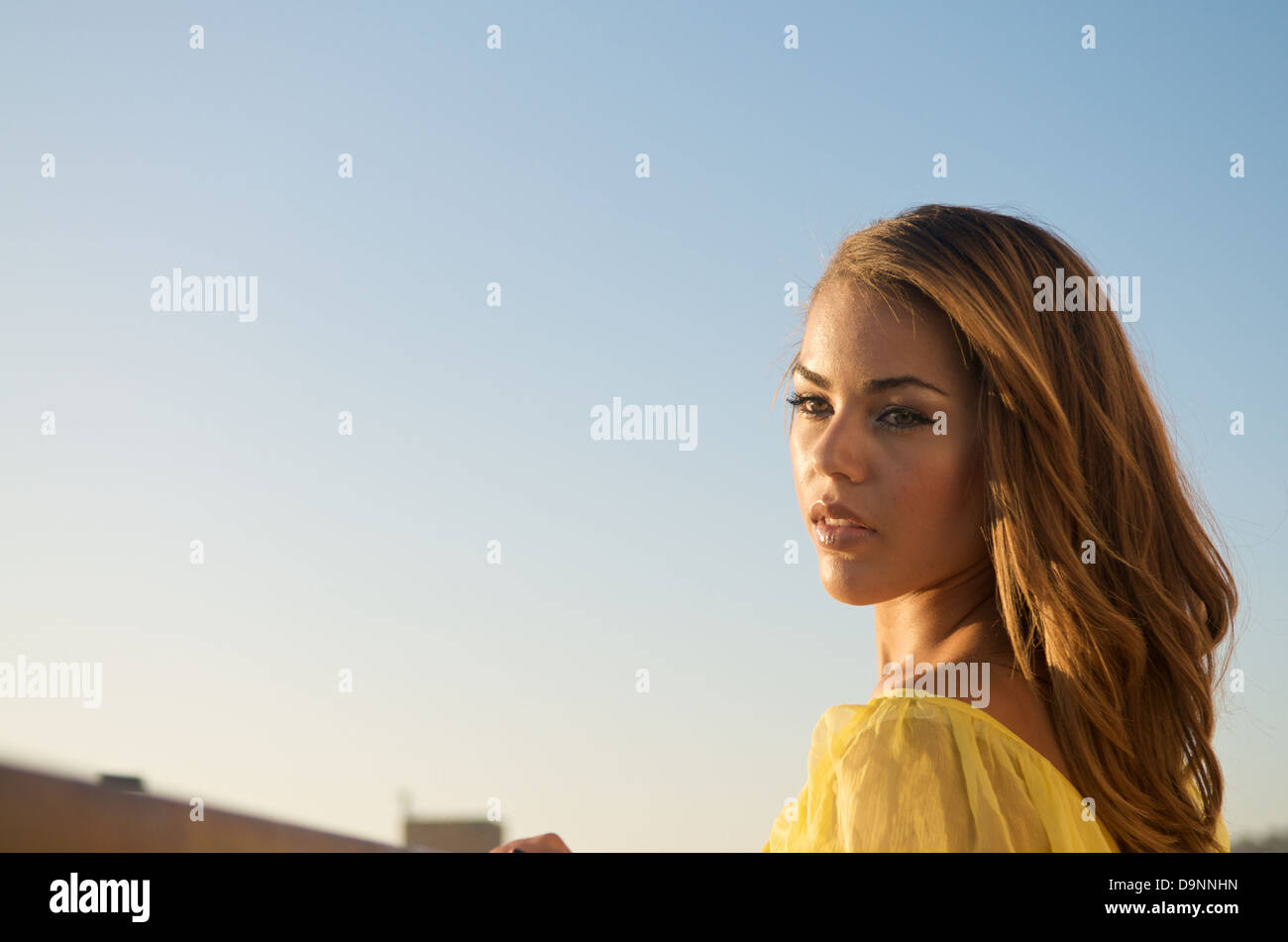 Portrait of beautiful multiracial model in yellow dress. Stock Photo