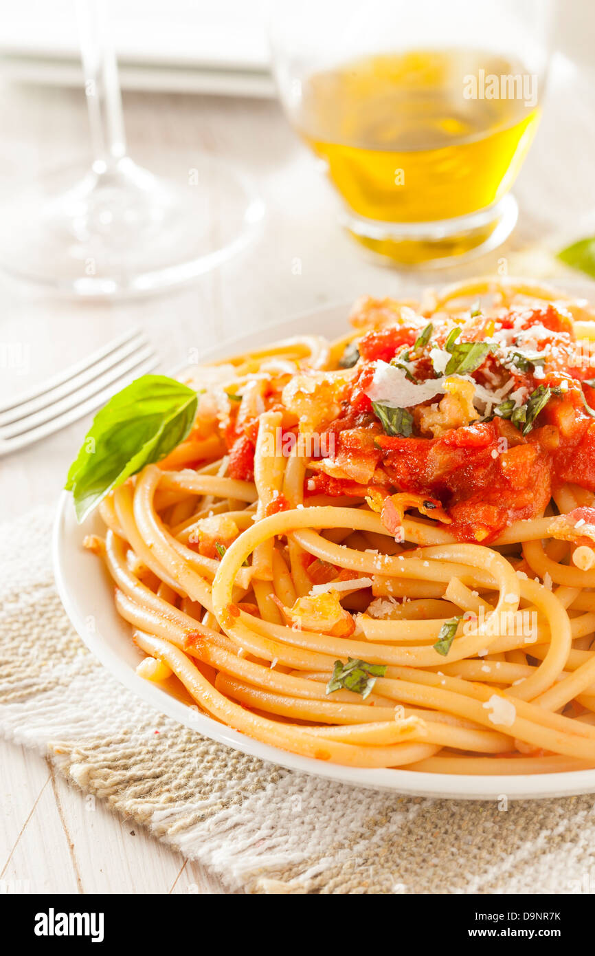 Homemade Bucatini Amatriciana Pasta with sauce and basil Stock Photo