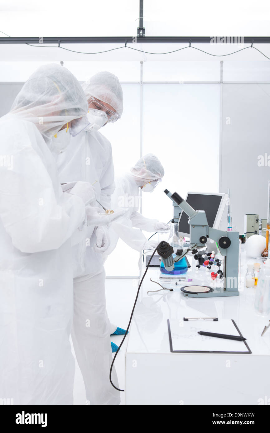 generalview of three scientists in a chemistry lab manipulating lab