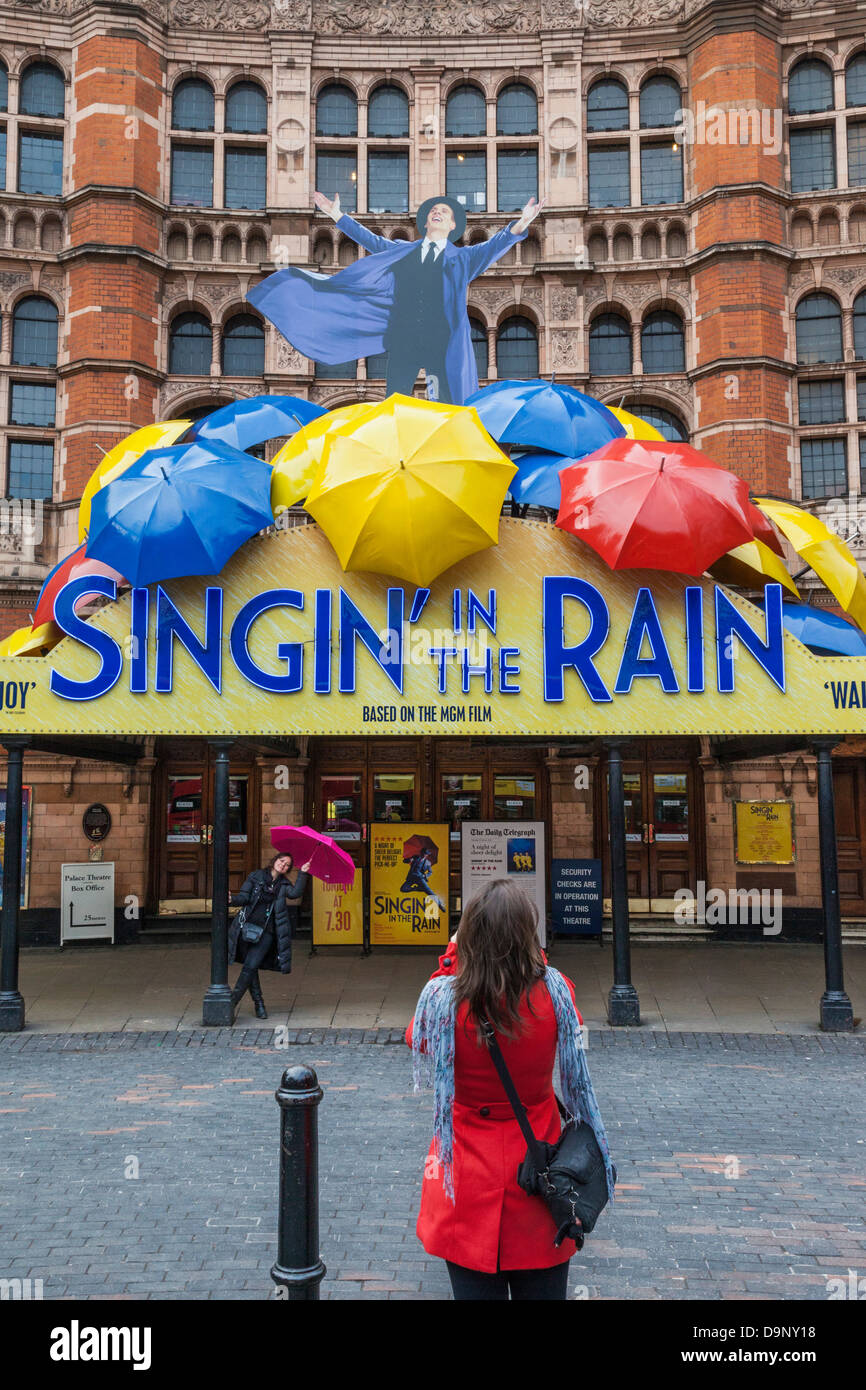 England, London, Soho, Female Tourist Posing with Umbrella in front of Palace Theatre Stock Photo