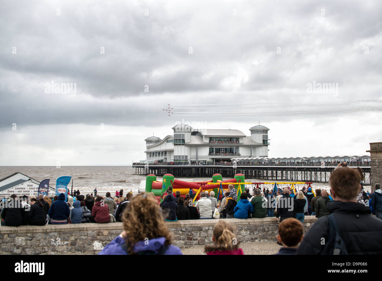 The crowds enjoy the British Red Arrows aerobatic display team perform over the Grand Pier at Weston Super Mare Stock Photo