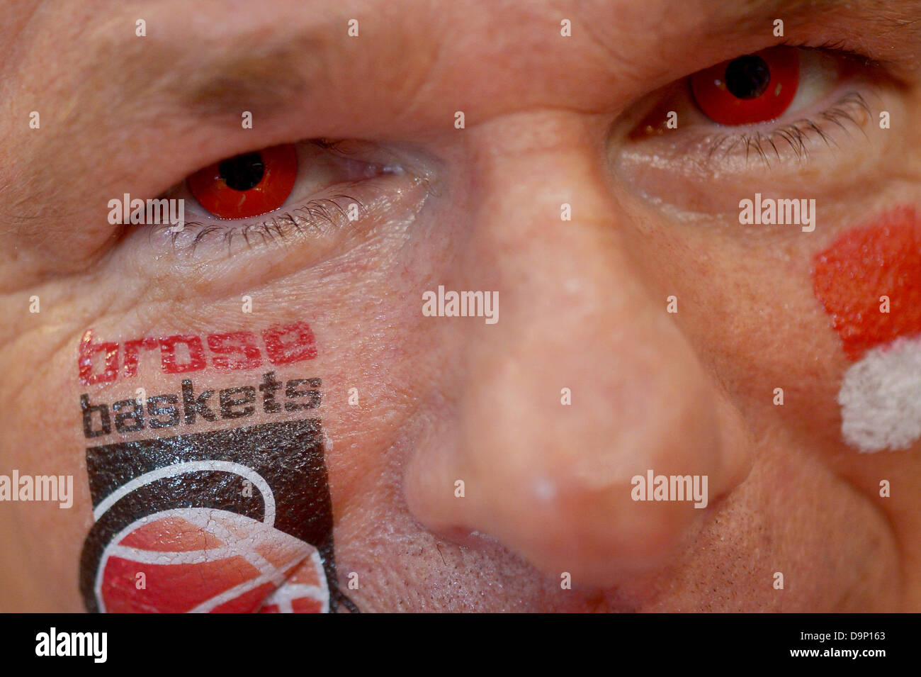 A fan of Bamberg wears red contact lenses and a Brose Baskets sticker