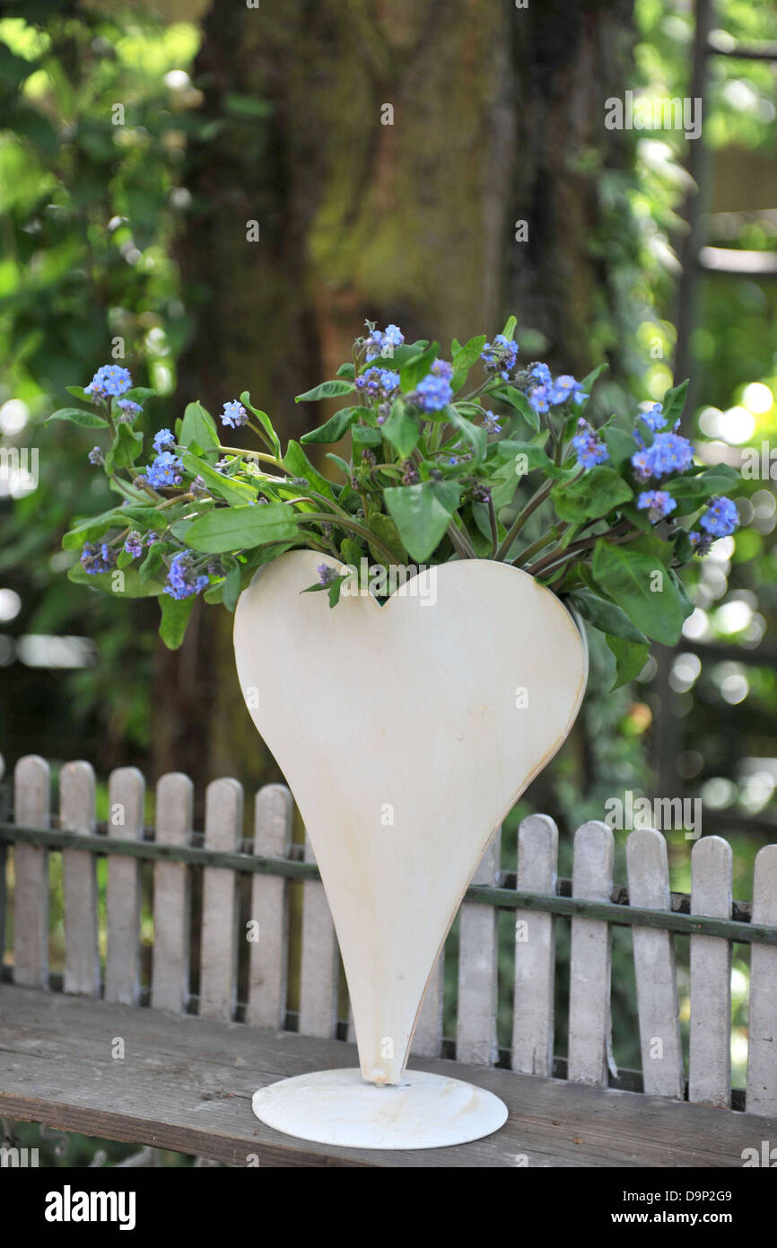 Forget me not in a heart-shaped vase Stock Photo