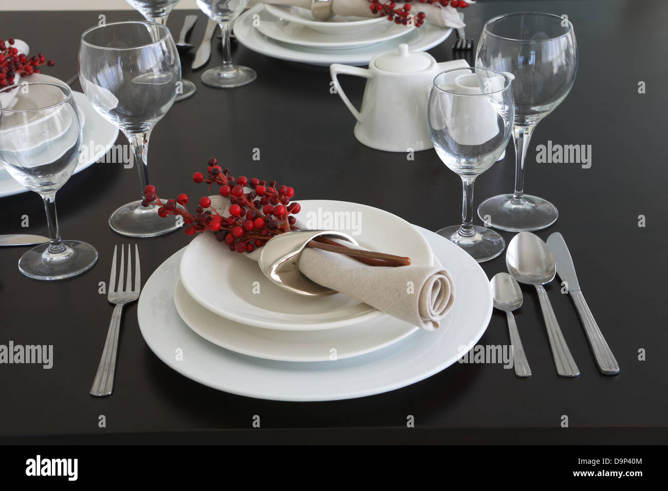 The table is styled and set for dinner. The white crockery and silver  cutlery contrast wonderfully against the dark wood table Stock Photo - Alamy