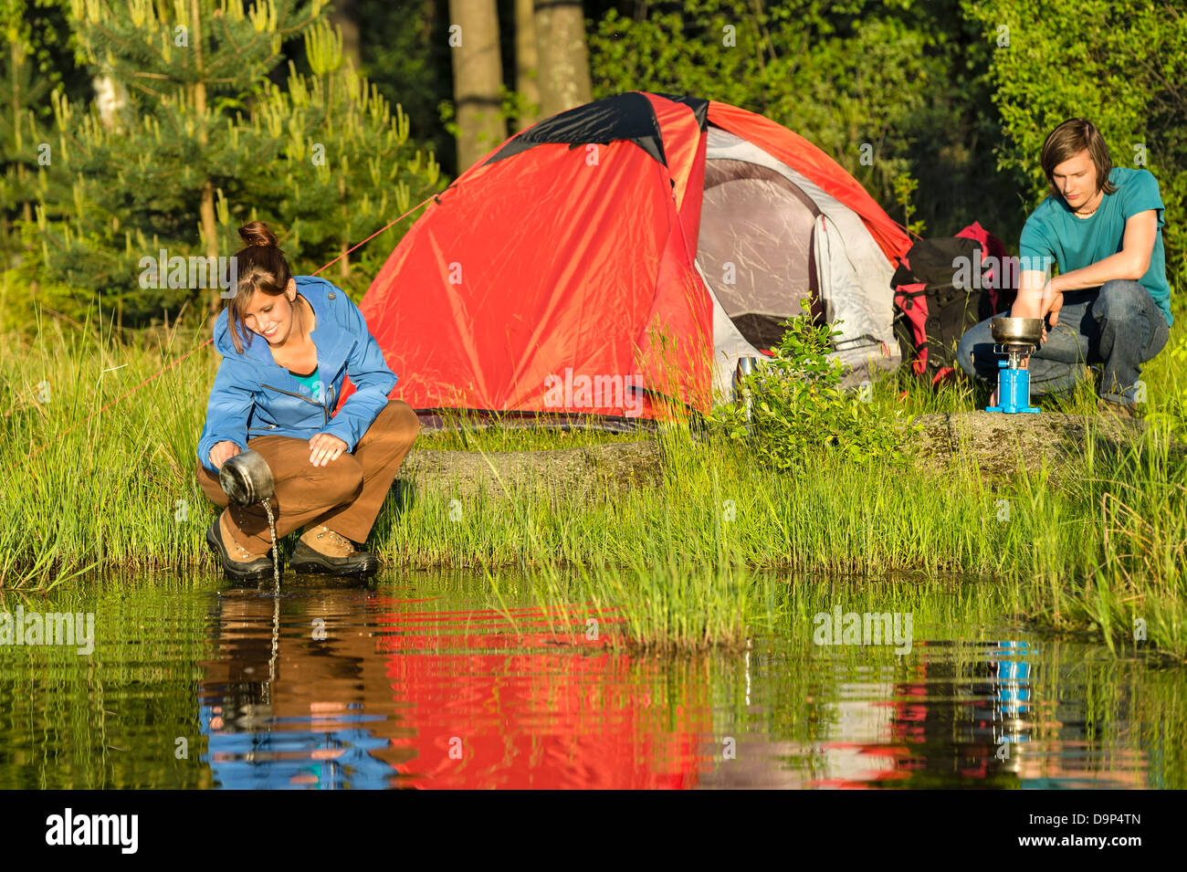 Camping couple heating the supper and washing pot Stock Photo