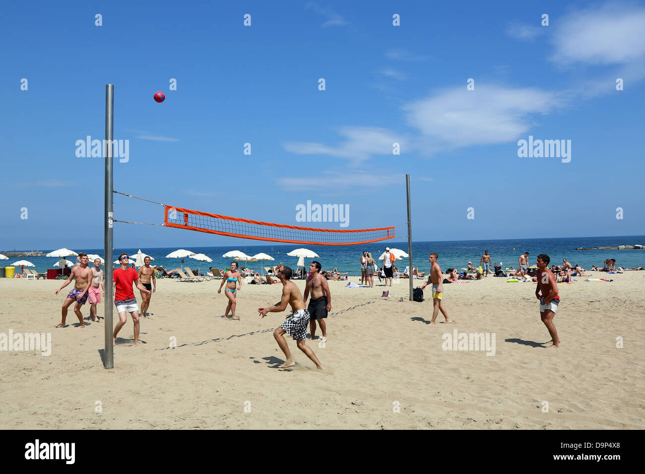 Scene of holiday makers playing volleyball on the beach, Barcelona, Spain Stock Photo