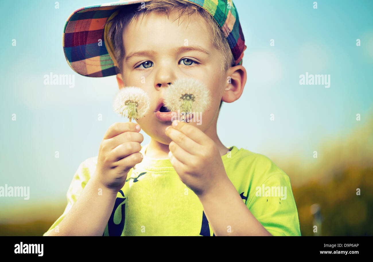 Little cute boy playing blowballs Stock