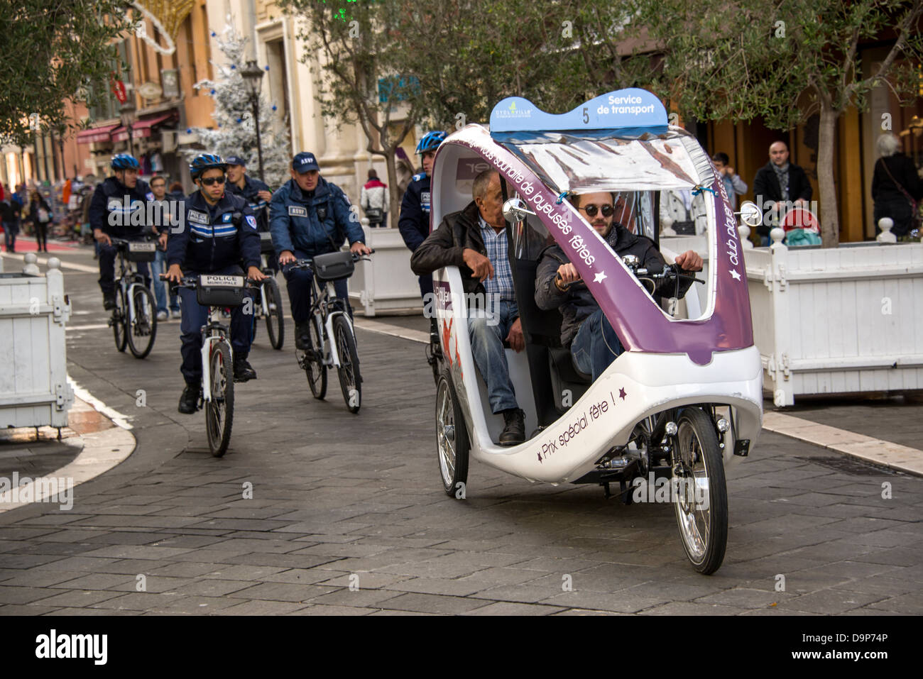 A cycle rickshaw and policemen on bikes in Nice France on the Côte d