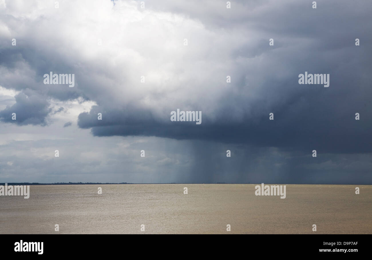 Heavy rain showers falling on sea from nimbocumulus cloud Orford Ness