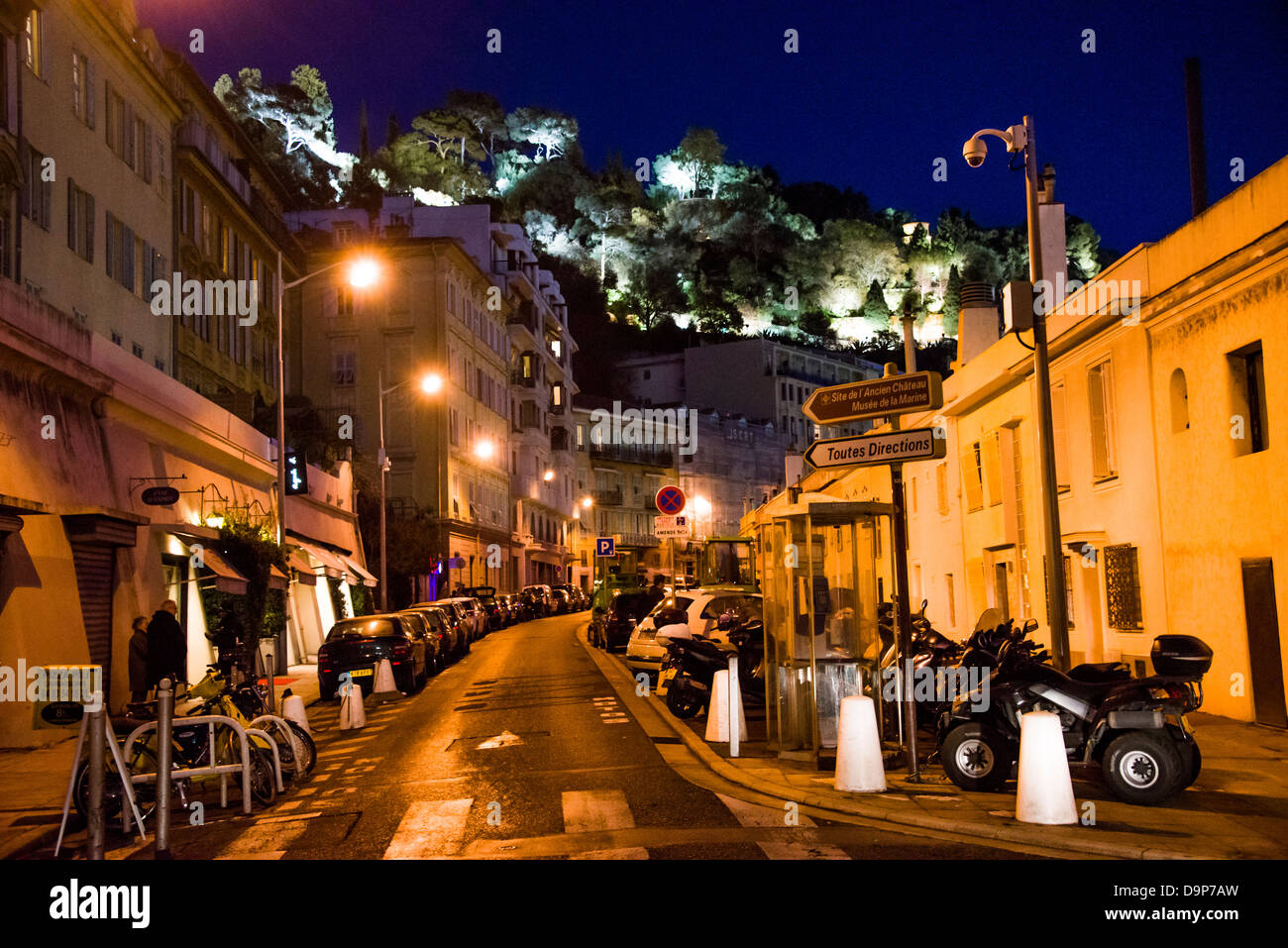 A small side street with parked cars next to the Promenade des Anglais in the old town of Nice France at night with Castle Hill Stock Photo