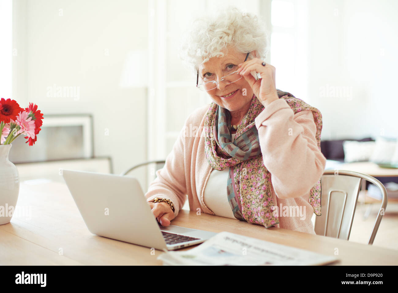 Portrait of a mature woman with laptop smiling at you Stock Photo