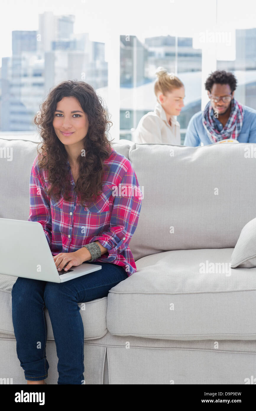 Attractive worker using laptop while sitting on a couch Stock Photo - Alamy