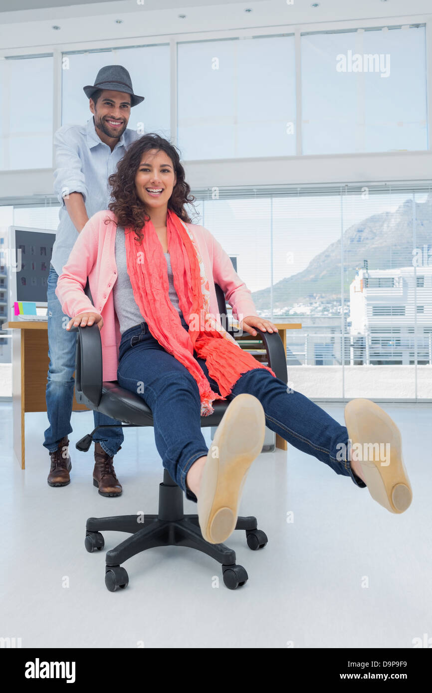 Creative business team having fun on a swivel chair Stock Photo