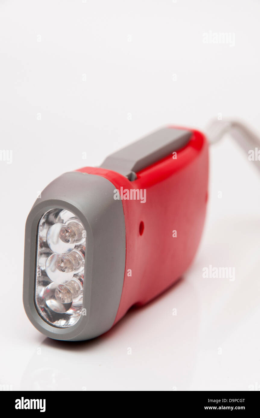 dynamo flashlight red color that can be charged via a pulley spinning Stock Photo