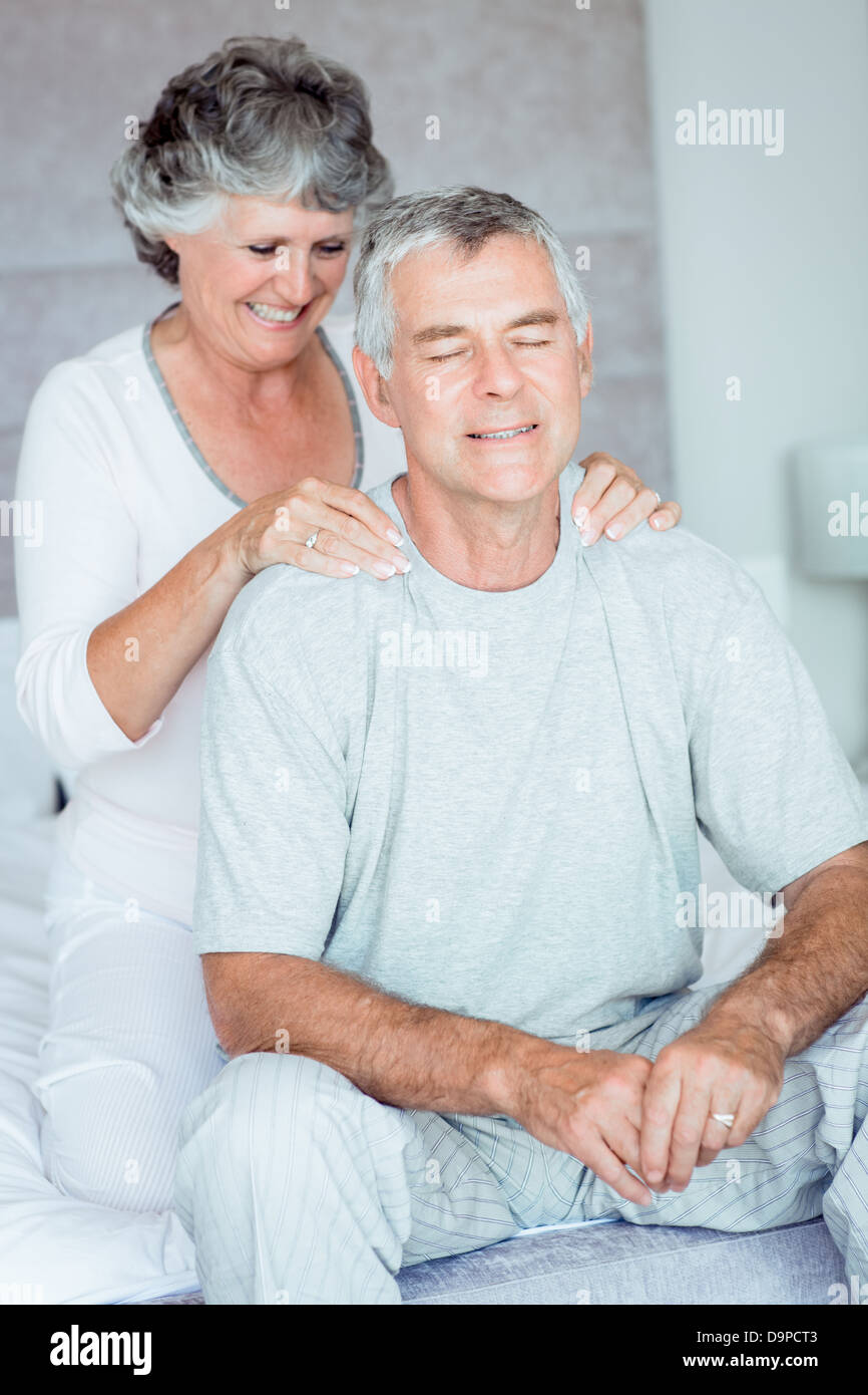 Mature woman giving a shoulder massage to her husband Stock Photo - Alamy