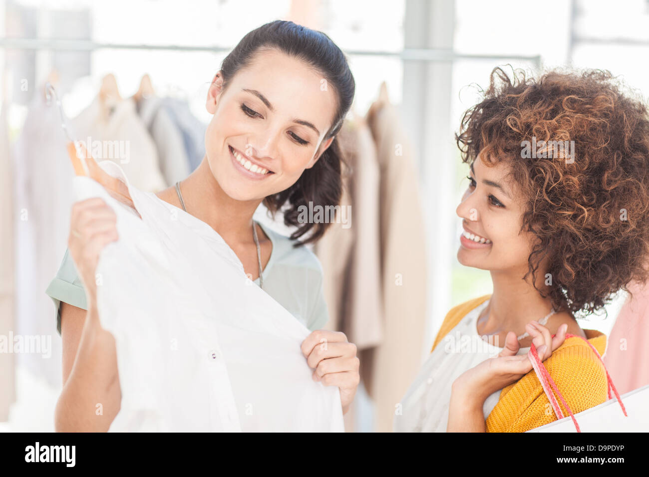 Attractive woman showing her new dress to her friend Stock Photo