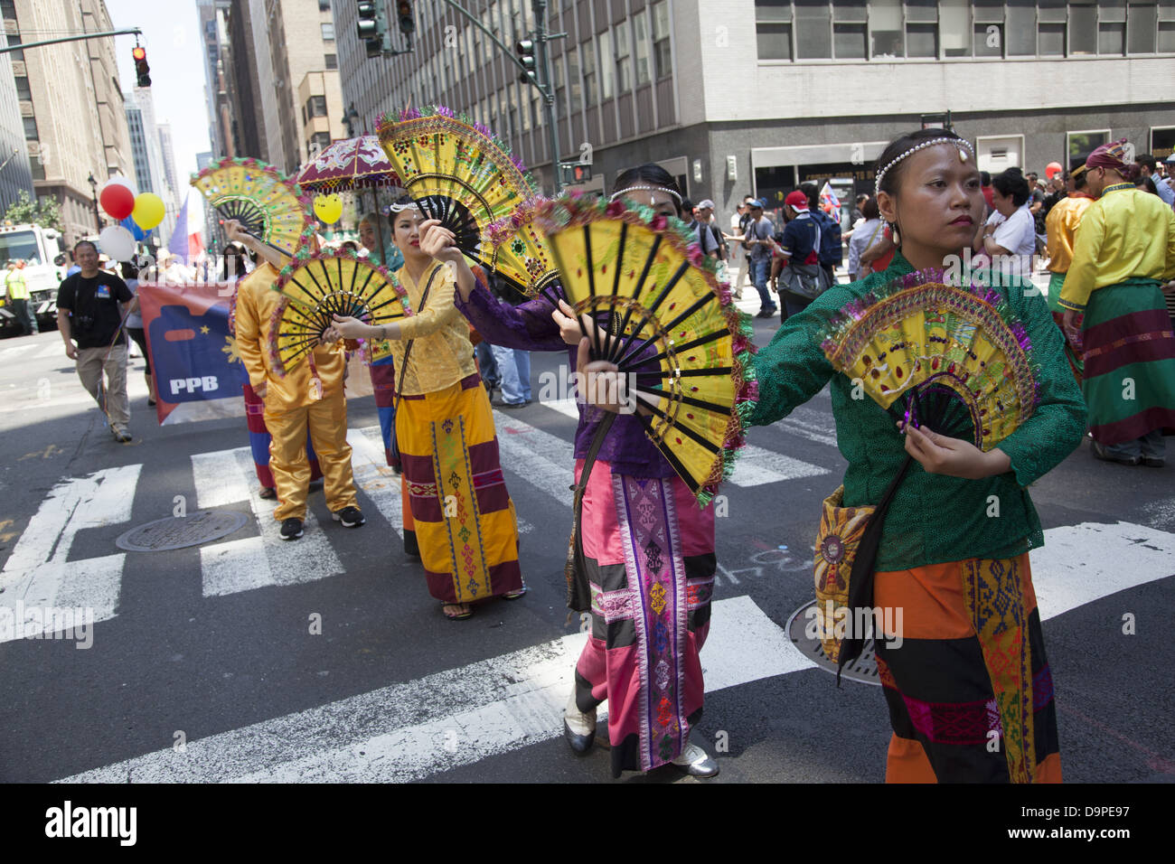Women in colorful costumes perform & march in the Filipino Parade on Madison Ave. in NYC Stock Photo