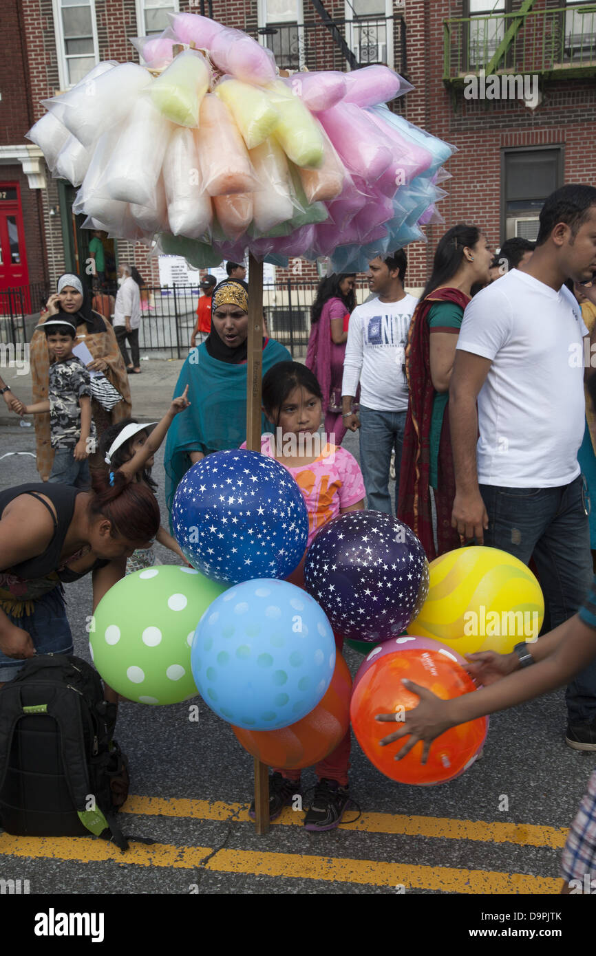 Hispanic mother & daughter sell colorful balloons & cotton candy at a street fair in at a Bangladeshi street fair, Brooklyn, NY Stock Photo