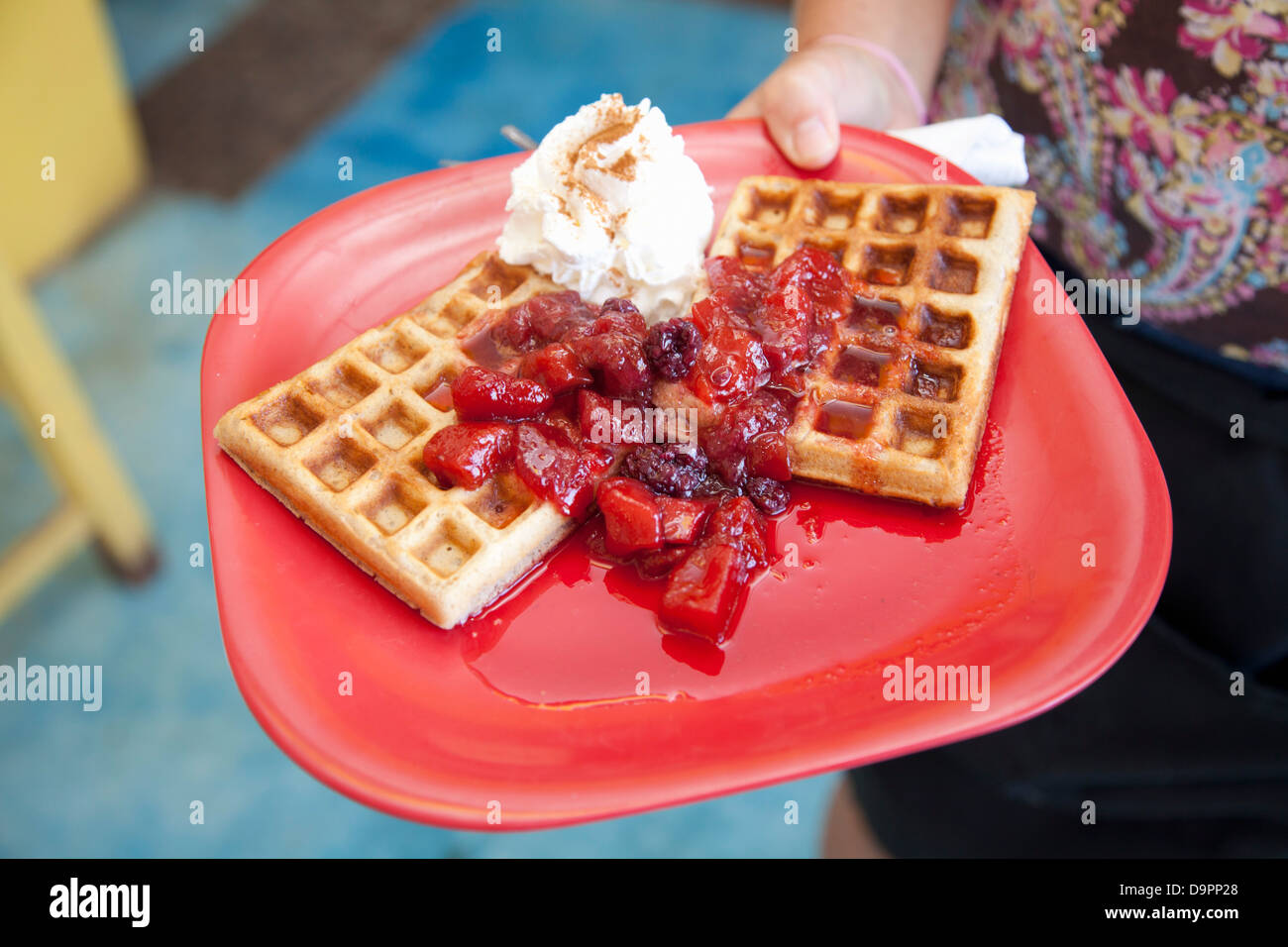 Woman holding plate of waffles Stock Photo