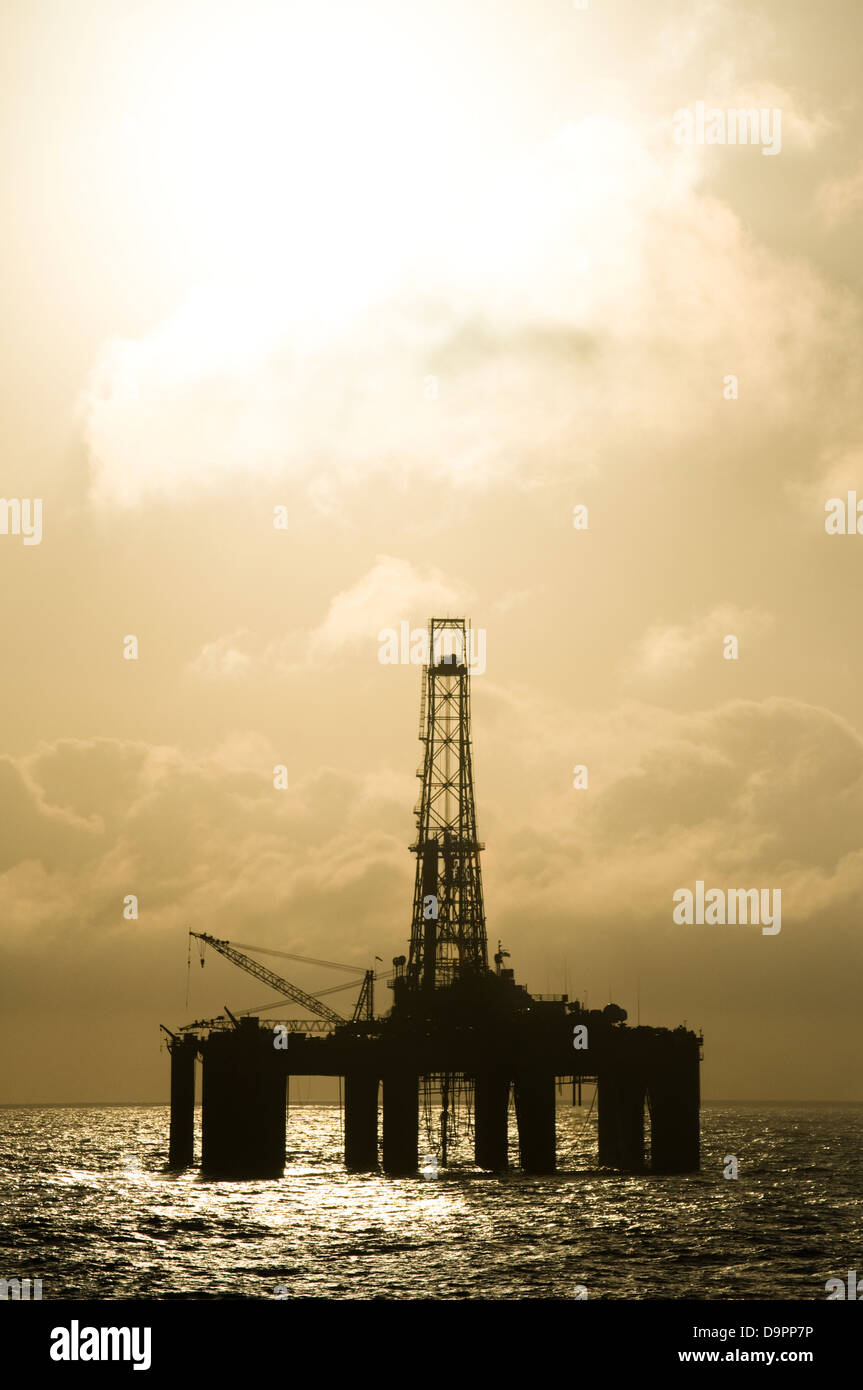 Silhouette of an offshore floating oil drilling rig. Deep sea at sunset ...