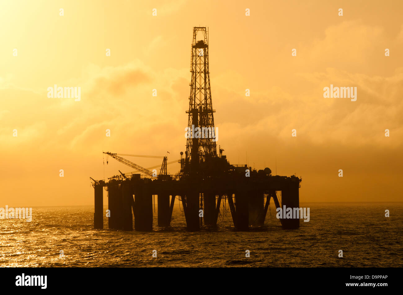 Silhouette of an offshore floating oil drilling rig. Deep sea at sunset ...