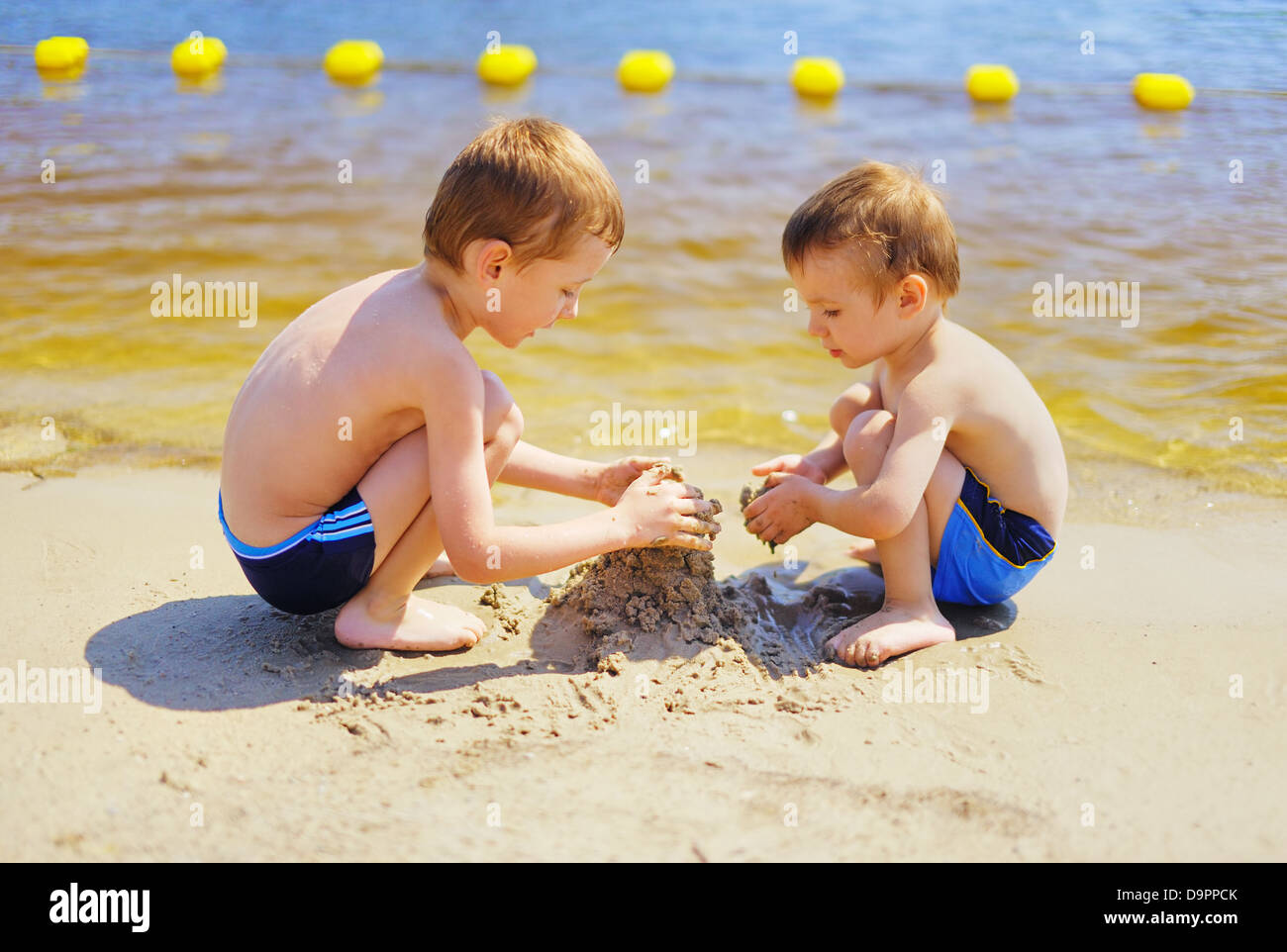 Two cute kids building sand castle on the beach Stock Photo Alamy