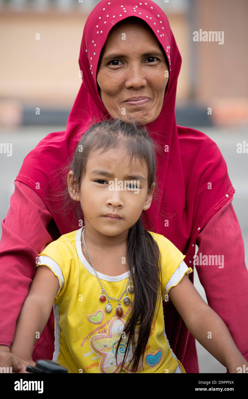 Portrait of Malaysian woman and girl on bike, Kota Bharu, Kelantan, Malaysia Stock Photo