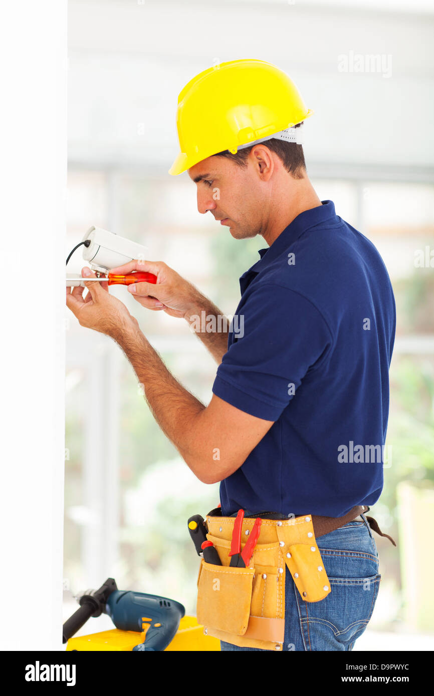 security surveillance system technician installing cctv camera Stock